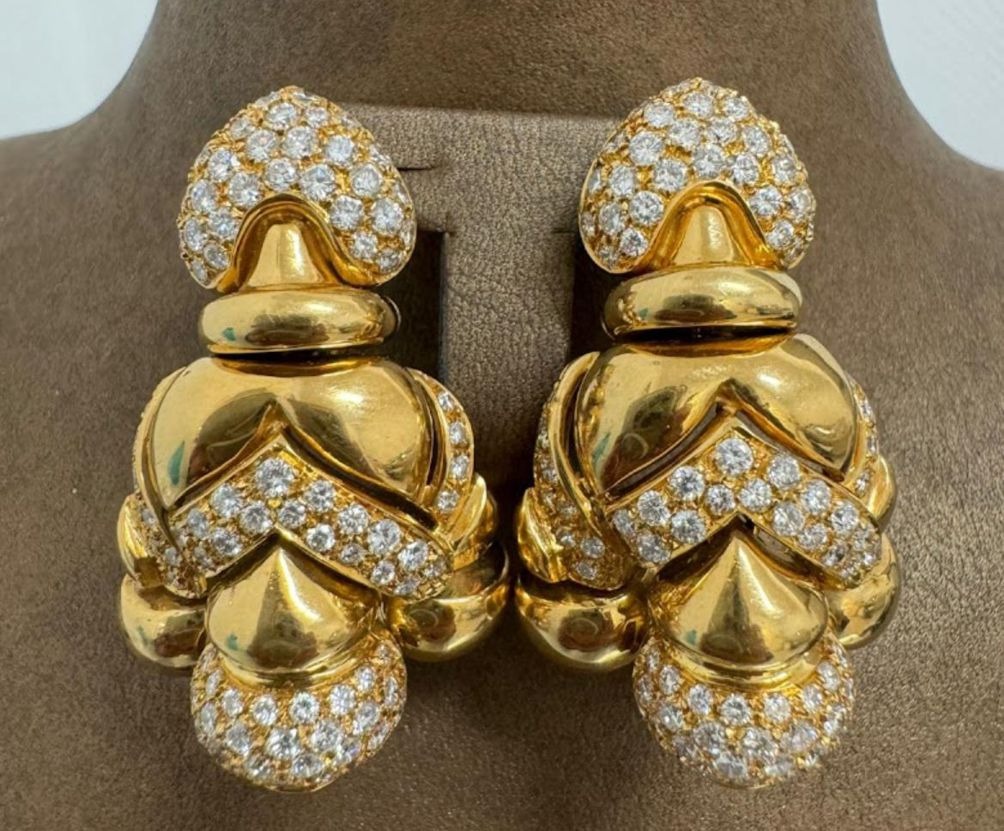 Goldene Ohrclips mit runden und herzförmigen Elementen und zahlreichen kleinen weißen Steinen