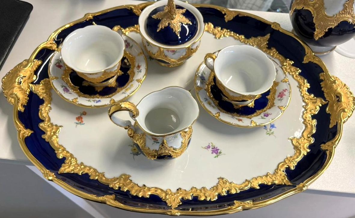 Ein reich verziertes Porzellan-Teeservice mit goldenen und blauen Akzenten auf Tablett